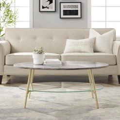 42 in. Grey Faux Marble Wood and Gold Metal Glam Oval Coffee Table with Lower Glass Shelf by Welwick Designs