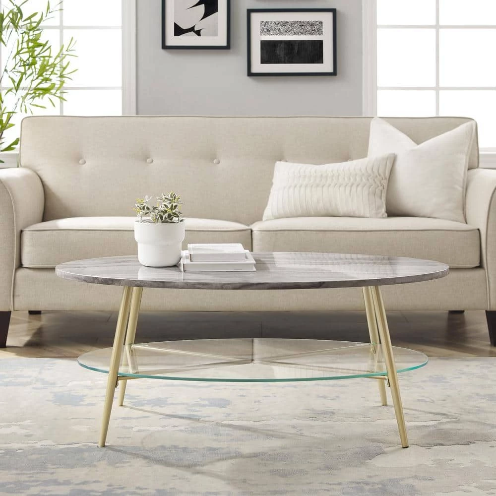 42 in. Grey Faux Marble Wood and Gold Metal Glam Oval Coffee Table with Lower Glass Shelf by Welwick Designs 1 42 in. Grey Faux Marble Wood and Gold Metal Glam Oval Coffee Table with Lower Glass Shelf by Welwick Designs